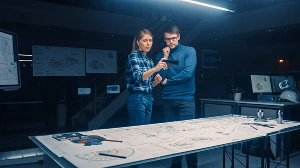 Due giovani ingegneri di sviluppo software parlano e utilizzano smartphone con realtà aumentata per la lettura e l'interazione con auto e motore Concept Blueprint sdraiati sulla scrivania — Foto Stock