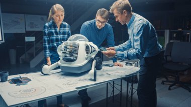 Robot Mühendislik Tesisi Üç Teknik Mühendisler Tekerlekli Robot Prototipi hakkında konuşuyor ve çalışıyor. Ekran Endüstriyel Tasarımı Gösteren Arkaplan Yüksek Teknoloji Araştırma Merkezi 'nde. Kara Vuruş