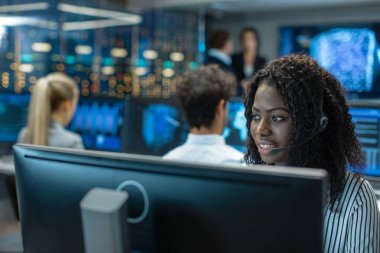 Erkek müşteri hizmetleri temsilcisi cevap müşterinin sorular bir kulaklık. O büyük bir teknoloji şirketi için çalışıyor. Show görüntüler yararlı Infographics Office uzmanları, çok etnik gruptan oluşan ekibe sahiptir.