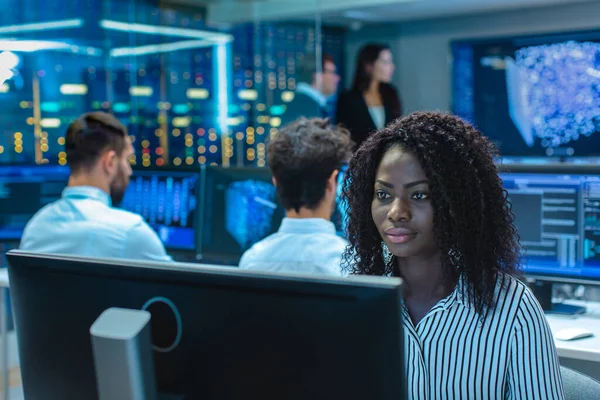 Kadın bilgisayar mühendisi Neural ağ üzerinde çalışır / yapay zeka proje uzmanı çok etnik gruptan oluşan ekibi ile. Birden çok ekran 3d Görselleştirme gösterilen göstermektedir.