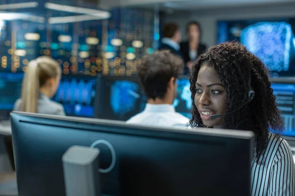 Erkek müşteri hizmetleri temsilcisi cevap müşterinin sorular bir kulaklık. O büyük bir teknoloji şirketi için çalışıyor. Show görüntüler yararlı Infographics Office uzmanları, çok etnik gruptan oluşan ekibe sahiptir.