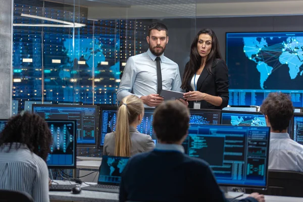 Bölüm Başkanı, Proje Yöneticisi Çalışma Sürecini Tablet Bilgisayarında Veri Kullanarak Tartışıyor. Çok Etnik Mühendisler Ekibi Çalışıyor. Nöral Ağ 'ın Çalışma Modelini Gösterir