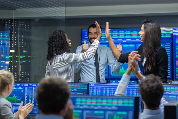 Équipe multi-ethnique de commerçants ont une journée réussie au bureau de la Bourse. Les courtiers achètent et vendent des actions sur le marché, ils célèbrent la transaction rentable. Écrans Affichage Infographies pertinentes — Photo