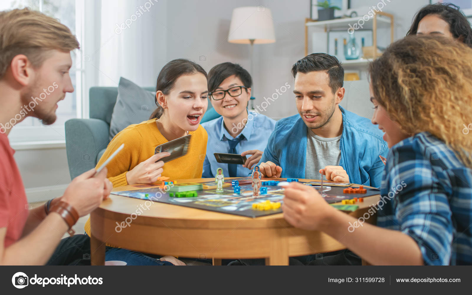 Group of diverse friends playing game on mobile phone Stock Photo