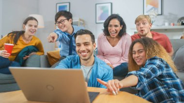 Çeşitli arkadaş grupları oturma odasında dizüstü bilgisayar kullanır. Mutlu Güzel Kızlar ve Erkekler Canlı Yayın ya da İzleme İçeriği. Eğleniyorlar ve gülüyorlar..