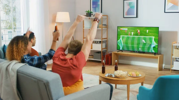 Oturma odasında bir koltukta oturan üç spor fanatiği televizyonda önemli futbol maçlarını izleyip, takımları için tezahürat yapan, takımına galibiyet getirdikten sonra 