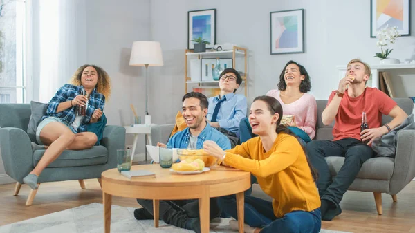 En casa Diverse Group Amigos viendo televisión juntos, comiendo bocadillos y bebiendo bebidas. Probablemente viendo juegos deportivos o películas divertidas . — Foto de Stock