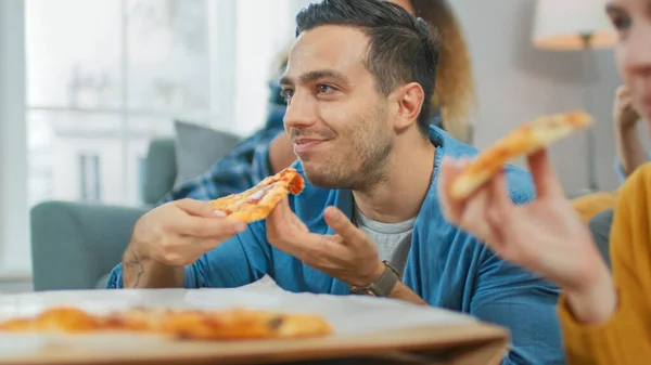 Thuis Diverse Groep Vrienden Kijken TV Samen. Portret van een man die lekkere pannenkoeken eet. Jongens en meisjes kijken naar komedie sitcom of een film, lachen en plezier hebben samen. — Stockfoto