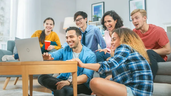 Diverso grupo de amigos utilizan el ordenador portátil en la sala de estar. Feliz Hermosa Chicas y Chicos Haciendo Transmisión en Vivo. Se divierten y ríen . — Foto de Stock