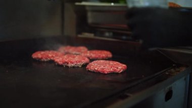 Bir Et Patty 'nin Izgarada Hazırlanışının Lezzetli Yakın Çekimi. Taze Biftek Sıcak Benzin veya Elektrikli Izgarada Kızartıldı. Aşçı, Taze Kıymalı Taze Et 'ten Burger için bir Patty çeşniliyor..