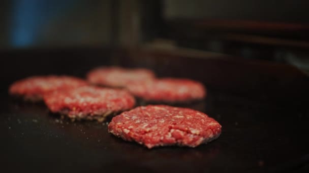 Tasty Close Up Footage of a Meat Patty Being Prepared on a Griller. Fresh Ground Beef is Grilled on a Hot Gas or Electric Grill. Cook is Seasoning a Patty for Burger from Fresh Minced Meat with Salt.