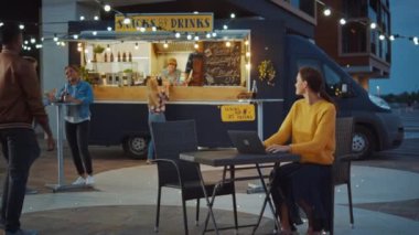 Güzel Esmer Kadın, bir sokak yemekhanesinde bir masada otururken dizüstü bilgisayarda çalışıyor. İnternet ya da Sosyal Medya 'ya bakıyor, Statü Güncellemesi gönderiyor. Emri Bekliyorum..