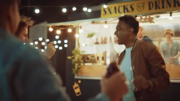 Groupe d'amis font une fête en dehors d'un café Burger Street Food. Ils dansent et passent à la musique tendance. C'est le soir dans un quartier moderne et cool. Tout le monde est heureux et plein de joie . — Video