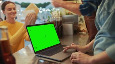 Yeşil Ekranlı Laptop Bilgisayar, Burger ve İçecek Satış yapan bir Yemek Kamyonunda veya Büfede bir tezgaha yerleştiriliyor. Mutlu Müşteriler Emirlerini Aldı.