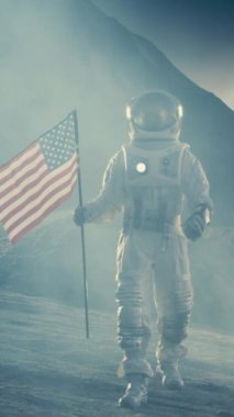 Güçlü Astronot, Amerika Birleşik Devletleri Bayrağı ile Karanlık Uzaylı Gezegeni 'nde yürüyor. Uzay Seyahati, Koloni Teması. Dikey Ekran Yönelimli Video Görüntüsü