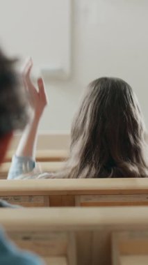 Konferans salonundaki öğrencilerin geçmişe bakış, bir profesörün ders vermesini dinlemek, bir öğrencinin elini kaldırması ve soru sorması. Dikey Ekran Yönelimli Video Görüntüsü 9: 16