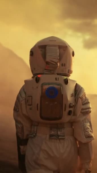 Astronautul de pe Marte mergând și explorând planeta în apropierea bazei / stației sale de cercetare. Misiune cu echipaj uman pe Marte, avansarea tehnologică aduce explorarea spațiului. Imagini video cu orientare verticală a ecranului — Videoclip de stoc