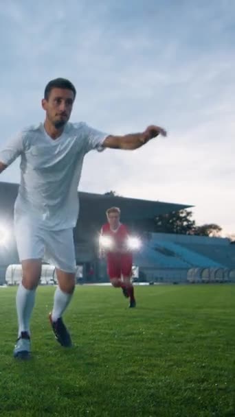 Jogador de futebol profissional supera membros da equipe adversária e chuta bola e marca objetivo. Sua equipe celebra a vitória. Filmagem de vídeo com orientação vertical da tela — Vídeo de Stock