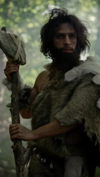 Portrait of Primeval Caveman Wearing Animal Skin and Fur Hunting with Stone Tipped Spear in the Prehistoric Forest. Neanderthal Scavenging with Primitive Tools. Video Footage with Vertical Screen 9:16 — Stock Video