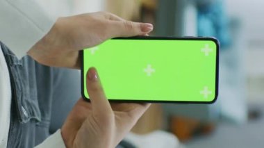 Genç Kadın Yeşil Mock-up Akıllı Telefonla Kanepede Uzanıyor 'u kullanıyor. Cep telefonunda Sosyal Ağları Kullanan Kız. Pov. Dikey Ekran Yönelimli Video Görüntüsü 9: 16