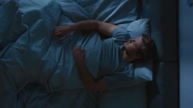 Gece Yatakta Korkunç Kâbus Gören Genç Bir Adam 'ın En İyi Görünüşü, Korkarak Uyanır ve Ter içinde Kalkar. Dikey Ekran Yönelimli Video Görüntüsü 9: 16