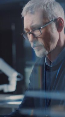 Profosyonel Elektronik Tasarım Mühendisi Araştırma Laboratuvarı 'nda dizüstü bilgisayarda gözlük takıyor, Kameraya Dönüyor ve Gülümsüyor. Dikey Ekran Yönlendirme Videosu 9: 16