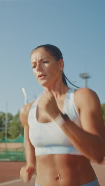 Krásná Fitness žena v světle modré sportovní top a legíny je spuštění Sprint běh na venkovním stadionu. Pomalý pohyb. Svislá orientace obrazovky Video 9: 16 — Stock video