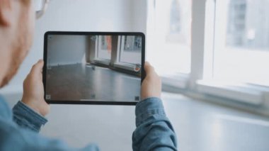 Gözlüklü Genç Hippi Boş Ofiste Duruyor ve Tablet Bilgisayarında Artırılmış Gerçeklik Yazılım Haritası Var. Video Yazılım için Kamera Uygulaması İzleme Noktaları Var.