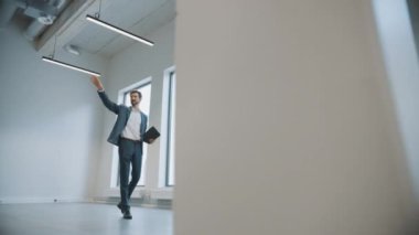 Genç Erkek ve Bayan Hippilere Yeni Boş Ofis Alanını Gösteren Emlakçı. Girişimciler Komisyoncuyla bir tabletle buluştu ve satın almak veya kiralamak istedikleri tesisi tartıştılar.