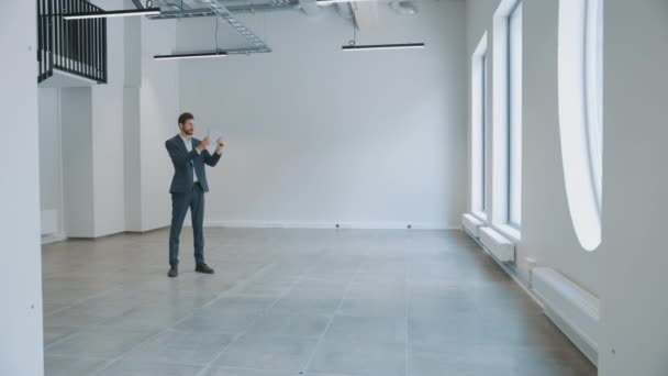 Businessman Standing in Empty Office and Map it with an Augmented Reality Software on a Tablet Computer. Entrepreneur Wears a Suit. Room Has Tracking Points for Video Software. — Stock Video