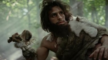 Hayvan Derisi Tutucu Taştan Mızraklı İlkel Mağara Adamı Etrafa Bakınıyor, Hayvan Avı Avında Tarih Öncesi Ormanı keşfediyor. Neanderthal Ormanda Avlanmaya Gidiyor