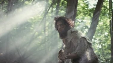 Hayvan Derisi Tutucu Taştan Mızraklı İlkel Mağara Adamı Etrafa Bakınıyor, Hayvan Avı Avında Tarih Öncesi Ormanı keşfediyor. Neanderthal Ormanda Avlanmaya Gidiyor
