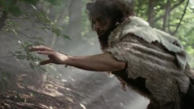 Hayvan Derisi Tutucu Taştan Mızraklı İlkel Mağara Adamı Etrafa Bakınıyor, Hayvan Avı Avında Tarih Öncesi Ormanı keşfediyor. Neanderthal Ormanda Avlanmaya Gidiyor