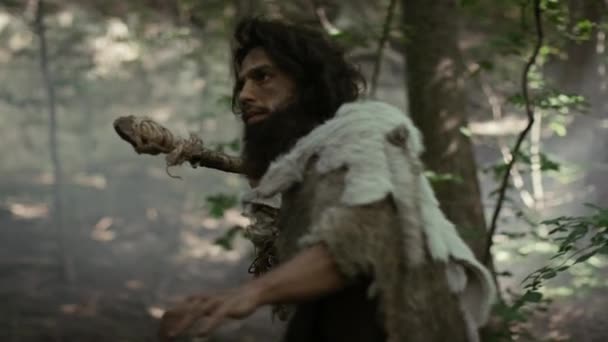 Primeval Caveman draagt Animal Skin Holds Stone Tipped Spear Looks around, verkent het prehistorische bos in een jacht naar dierlijke prooi. Neanderthaler gaat jagen in de Jungle — Stockvideo