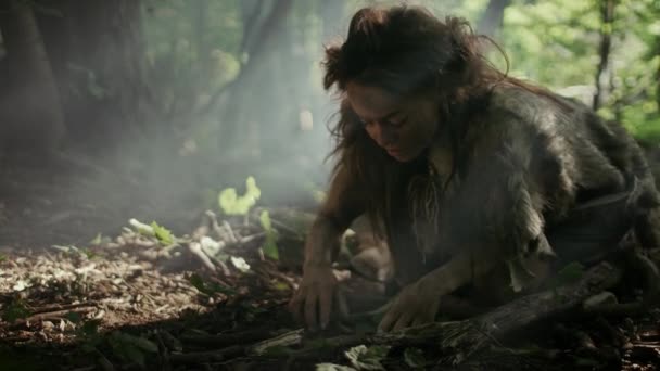 Доисторическая пещерная женщина-охотница-гатчиха за ягодами в лесу. Первобытная неандерталька в поисках пищи в солнечном лесу — стоковое видео