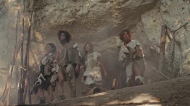 Avcı-Toplayıcılar kabilesi Hayvan Derisi Tutma Taşı Taşı Giyen, Mağara girişinin yanında duran Ormanda Avlanmaya Hazır Neandertal Ailesi veya Göç