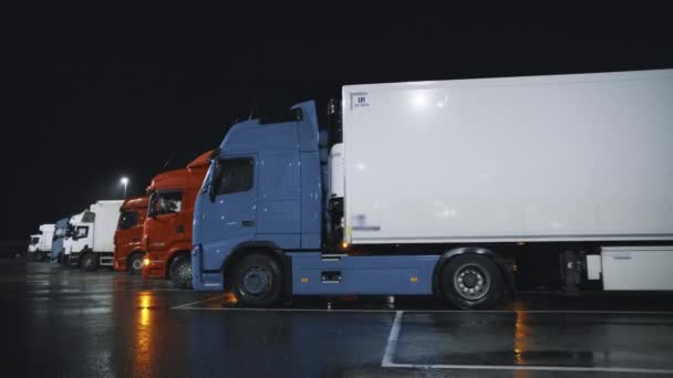 Линия полугрузовиков с грузовыми прицепами, стоящими на ночном парковочном месте. Водители ночуют на штрафстоянках. Moving Shot Лицензионные Стоковые Видео