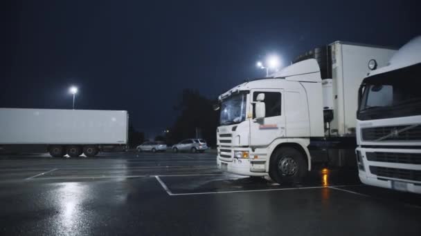 Blue Semi-Truck with Cargo Trailer Drives into Overnight Parking Space where Other Trucks are Standing. Водители ночуют на ночной парковке Лицензионные Стоковые Видео
