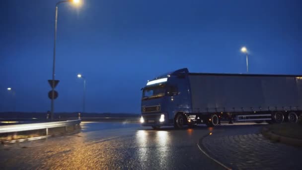 Blue Long Haul Semi-Truck met Cargo Trailer Vol met Goederen Reizen 's nachts op de snelweg, rijden over continent door regen, mist, sneeuw. Industriële magazijnen. Voorzijde Volgend schot — Stockvideo