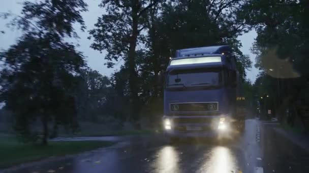 Long Haul Semi-Truck with Cargo Trailer Full of Goods Travels on the Rural Road. Jízda v brzkém ránu přes kontinent přes déšť, mlha. Pohled zepředu po výstřelu