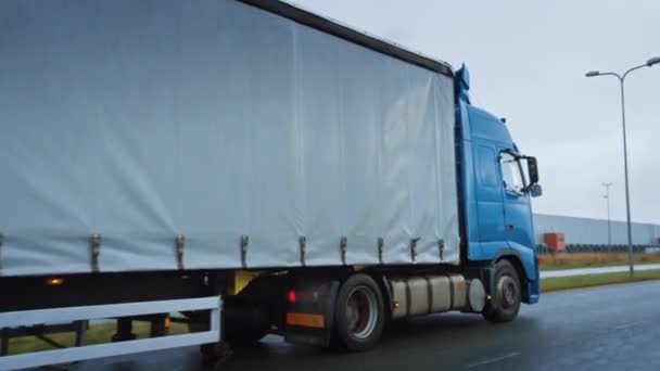 Long Haul semi-caminhão com reboque de carga cheio de mercadorias viaja na estrada da estrada. Diurno dirigindo através do continente através da chuva, nevoeiro. Área de Armazéns Industriais. Tiro de arco de ultrapassagem ativa — Vídeo de Stock