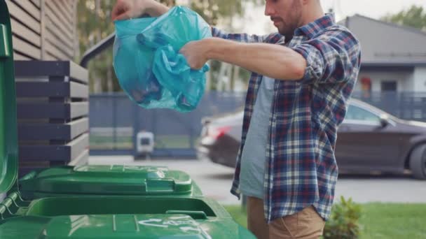 Hombre caucásico con camisa a cuadros está tirando botellas de una bolsa de plástico a la papelera. Utiliza la papelera correcta porque esta familia está clasificando los residuos y ayudando al medio ambiente. — Vídeos de Stock