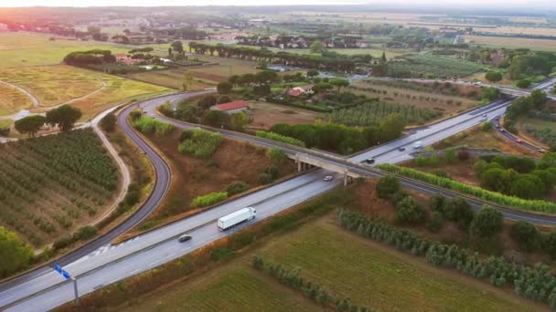 Εναέρια Drone View: Big Highway in Italy Περιτριγυρισμένο από αγροκτήματα, φυτείες γεωργικών προϊόντων, φυτείες λαχανικών — Αρχείο Βίντεο