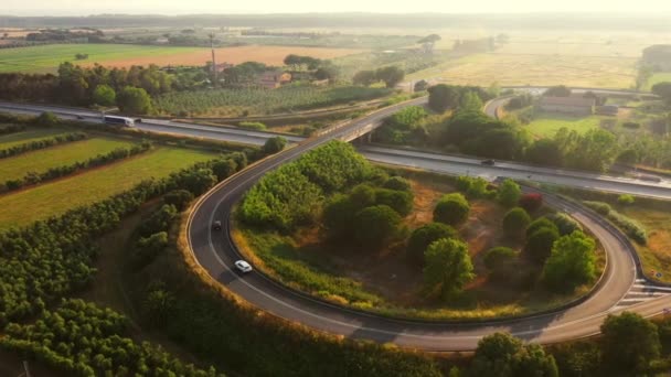 Drohnenaufnahmen aus der Luft: Sattelschlepper auf der vielbefahrenen Autobahn in der ländlichen Region Italiens. Schöne Naturkulisse und Fortschritt in der menschlichen Logistik — Stockvideo