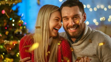 Noel arifesinde yakışıklı bir adam ve güzel bir kadın kucaklaşıyor ve gülümsüyor. Sevgili çift, Şut Konfeti ile iyi vakit geçirin..