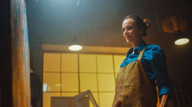 Boyalı Fırça Enerjisi ile Yetenekli Kadın Ressam, Yağlı Resmin Modern Başyapıtını Yaratıyor. Grevci Renklerin Büyük Tablosu ile Yaratıcı Stüdyo. Düşük Açı Portresi