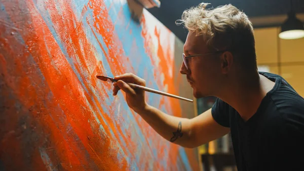 Portrait of Talented Artist Working on Abstract Painting, Uses Paint Brush To Create Daringly Emotional Modern Picture. Dark Creative Studio Large Canvas Stands on Easel Illuminated. Side View Close-up Shot — Stock Photo, Image