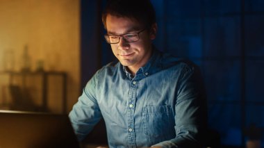 Ofis Stüdyosunda Masasında oturan Profesyonel Adam Akşam Dizüstü bilgisayar üzerinde çalışıyor. Data ile çalışan, İstatistikleri analiz eden, Bilgi yazan adam.