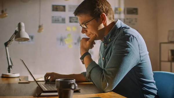 Professionelle kreative Mann sitzt an seinem Schreibtisch im Homeoffice-Studio an einem Laptop arbeiten und denken. Mann, der mit Daten arbeitet und Statistiken analysiert. — Stockfoto