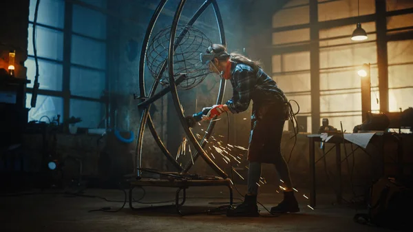 Talented Emerging Female Artist is Adding Finishing Touches to an Abstract, Brutal Metal Sculpture with an Angle Grinder. Beautiful Young Tomboy Girl Steps Back and Contemplate the Art Piece. — Stock Photo, Image